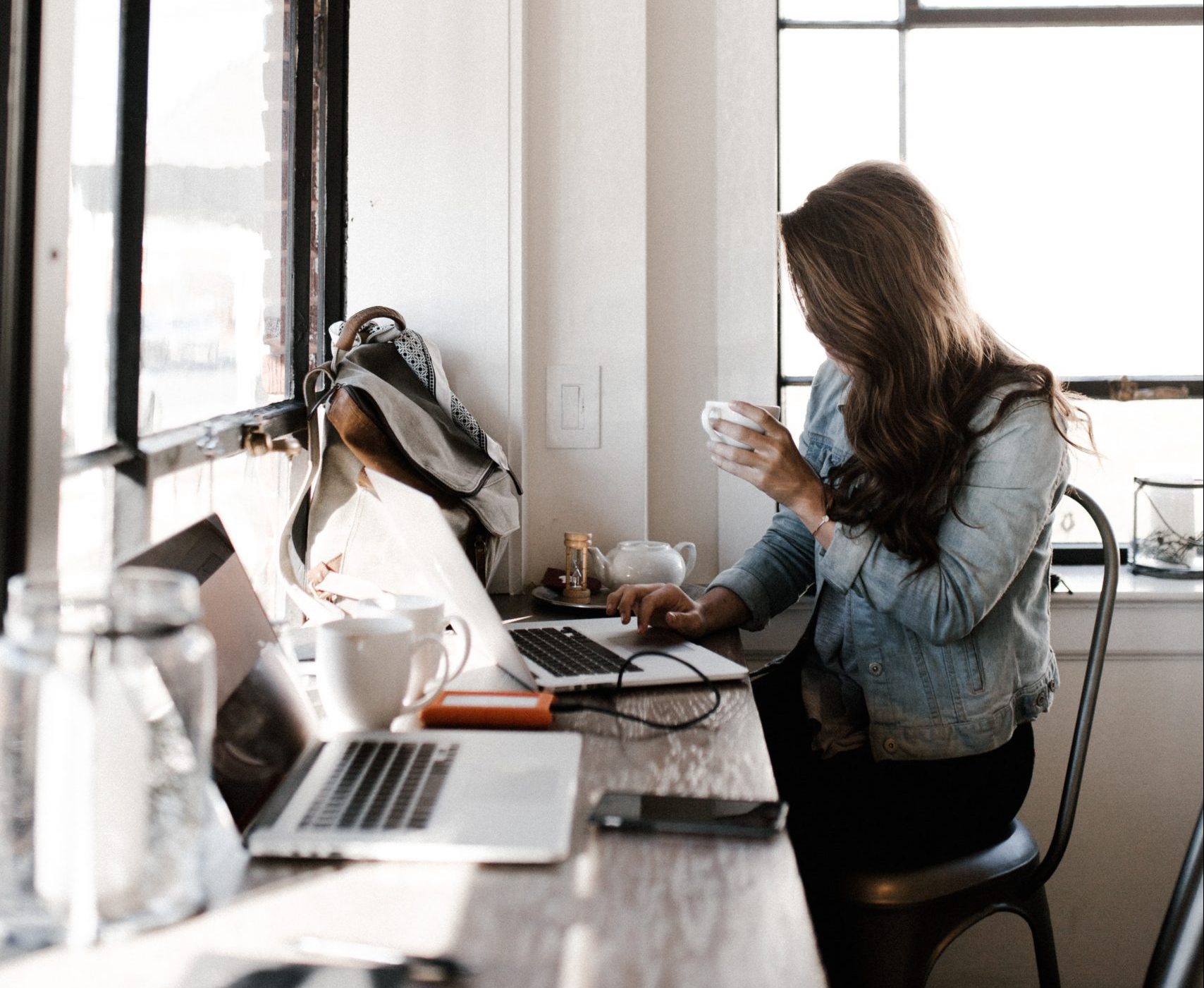 A woman with a coffee in a coworking space